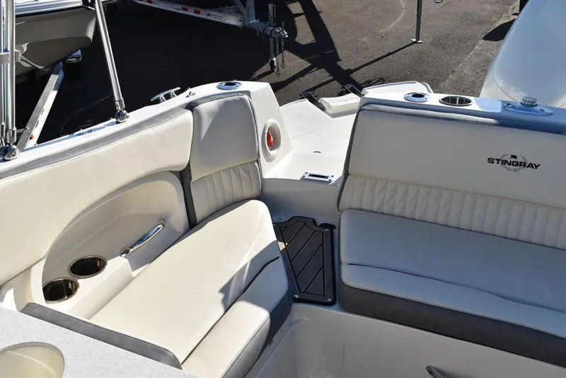 Slide: The Image of 2024 Stingray 231DC boat interior with white cushioned seating and cup holders. - 27