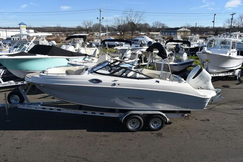 Slide: The Image of 2024 Stingray 231DC boat on a trailer in a marina. - 3