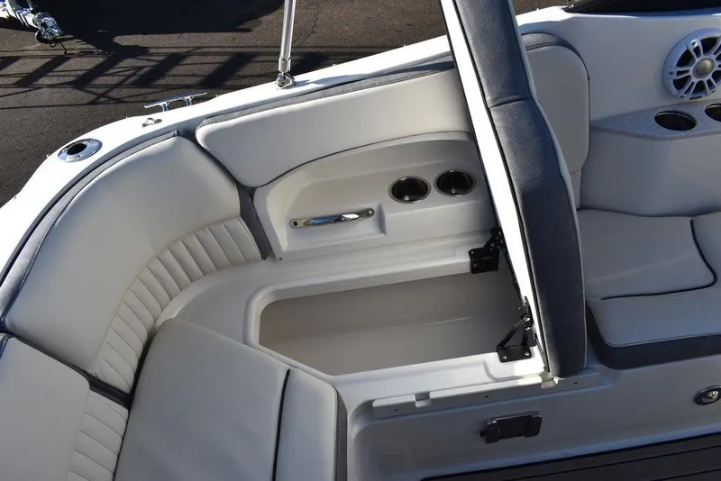 Slide: The Image of 2024 Stingray 231DC boat interior storage compartment with cup holders and cushioned seating. - 32