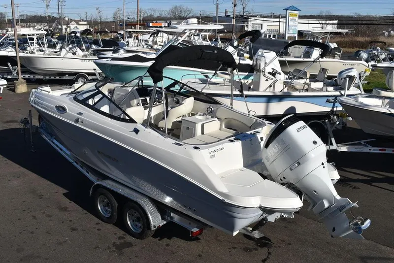 Slide: The Image of 2024 Stingray 231DC boat on a trailer in a marina. - 4