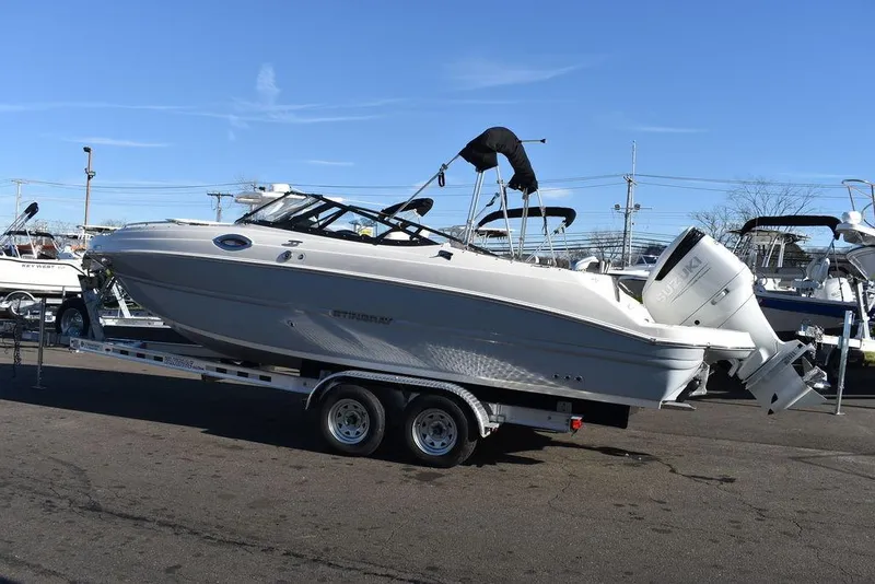 Slide: The Image of 2024 Stingray 231DC boat on a trailer in a marina. - 5