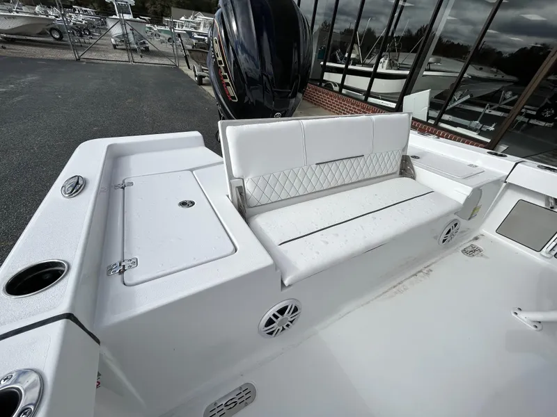 Slide: The Image of 2024 Sportsman Masters 227 Bay Boat with white seating and storage compartments. - 13