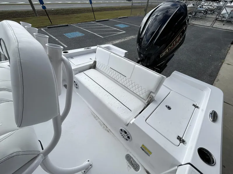 Slide: The Image of 2024 Sportsman Masters 227 Bay Boat with white seating and outboard motor. - 21