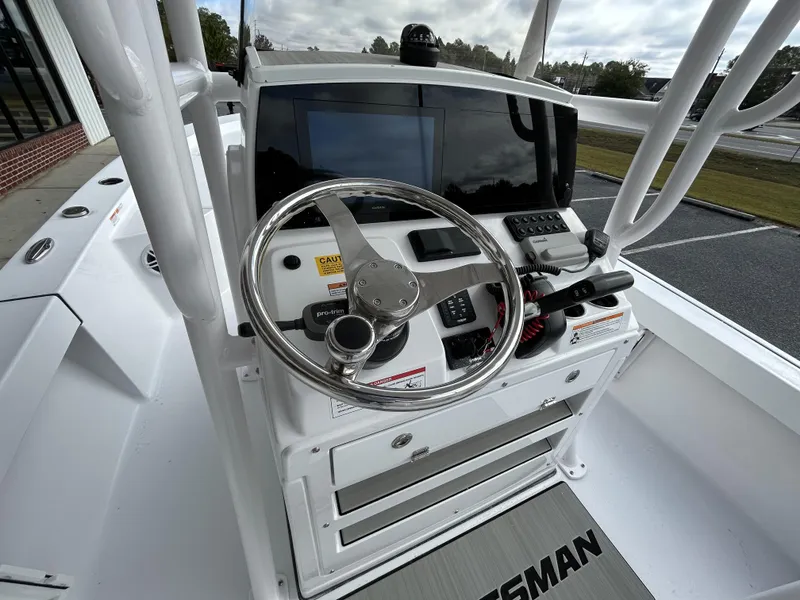 Slide: The Image of 2024 Sportsman Masters 227 Bay Boat helm with steering wheel and navigation controls. - 23