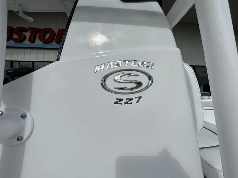 Slide: The Image of 2024 Sportsman Masters 227 Bay Boat logo on white surface. - 6