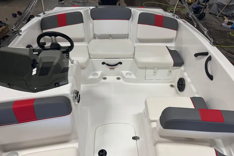 Slide: The Image of 2024 Tahoe T16 boat interior with red and gray seating, steering wheel, and storage compartments. - 14