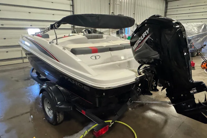 Slide: The Image of 2024 Tahoe T16 boat with Mercury engine in a garage setting. - 4