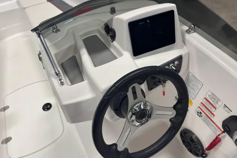 Slide: The Image of 2024 Tahoe T16 boat dashboard with steering wheel and control panel. - 6