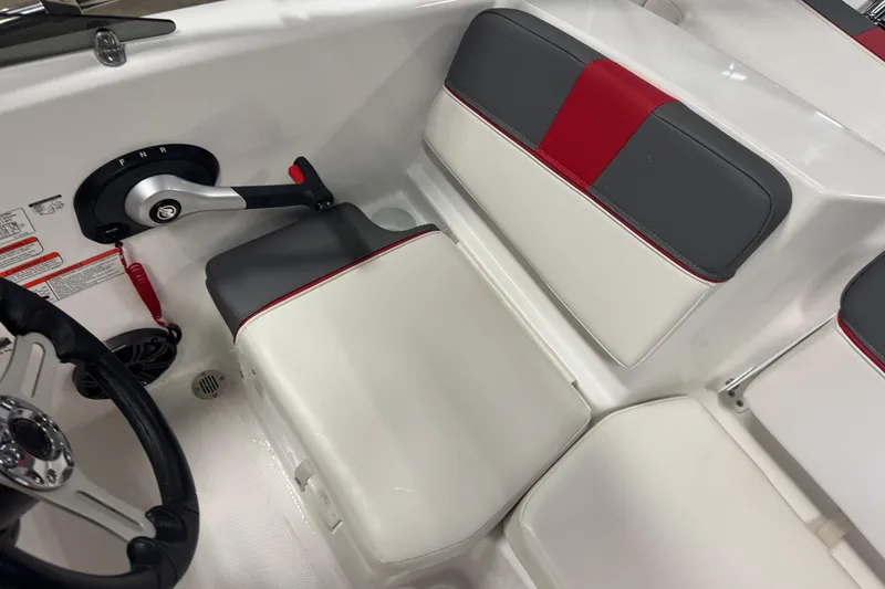 Slide: The Image of 2024 Tahoe T16 boat interior with steering wheel and control panel, featuring red and gray seating. - 8