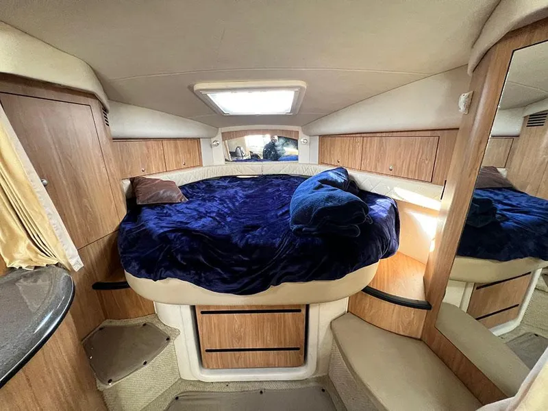 Slide: The Image of 2006 Sea Ray 340 Sundancer cabin with cozy bed and wooden cabinetry. - 15