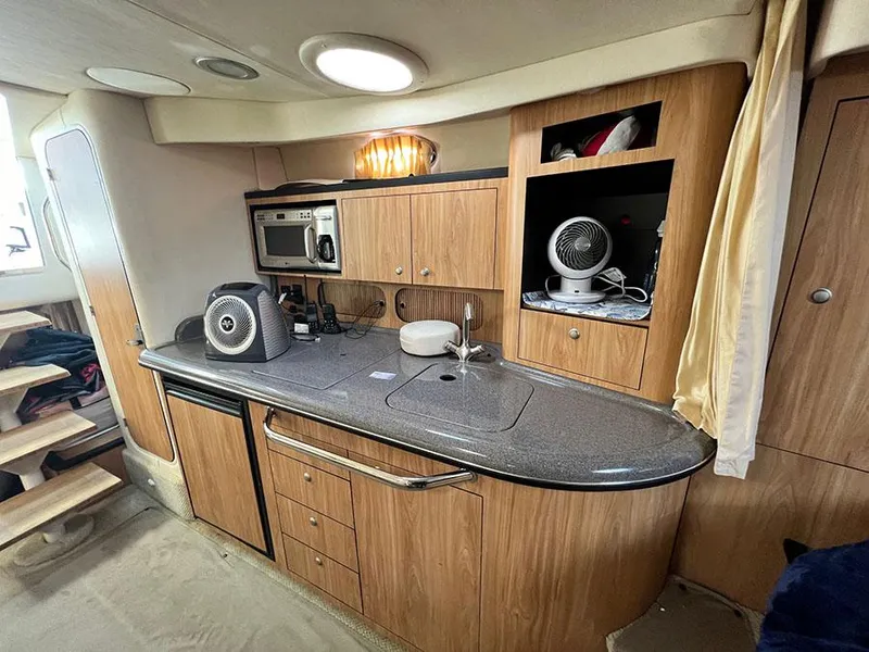 Slide: The Image of 2006 Sea Ray 340 Sundancer galley with microwave, sink, and storage cabinets. - 16