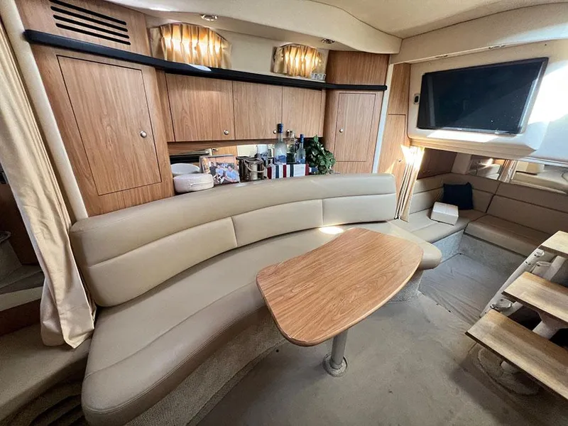 Slide: The Image of Interior of 2006 Sea Ray 340 Sundancer yacht with beige seating, wooden cabinets, and mounted TV. - 17