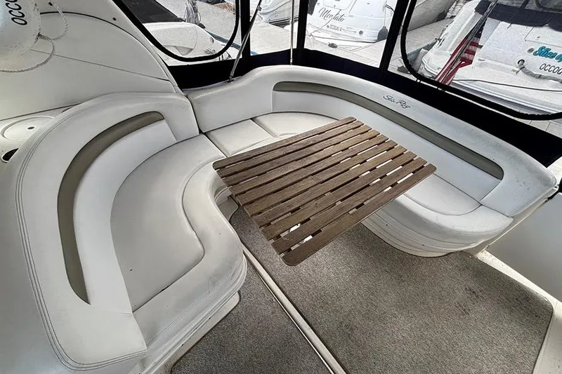 Slide: The Image of 2006 Sea Ray 340 Sundancer interior with curved seating and wooden table. - 6