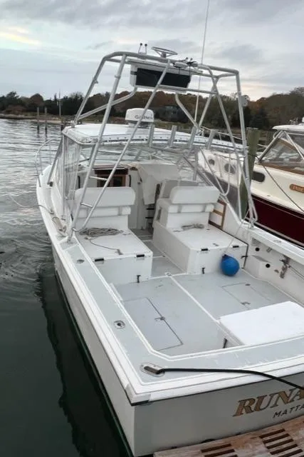 Slide: The Image of 1987 Black Watch 30 EXPRESS boat docked, featuring spacious deck and seating. - 2