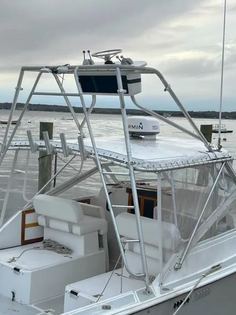 Slide: The Image of 1987 Black Watch 30 EXPRESS boat docked, featuring a Garmin radar and open seating area. - 3