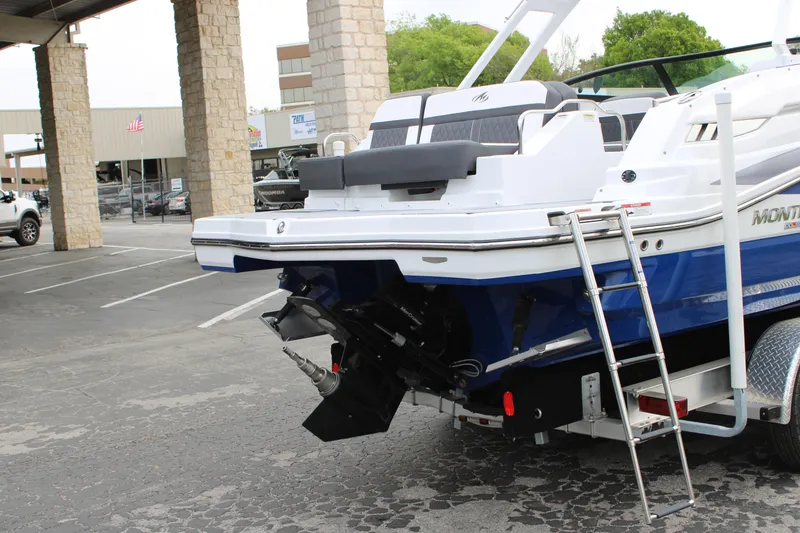 Slide: The Image of 2023 Monterey M6 boat rear view with ladder and outboard motor in parking lot. - 12