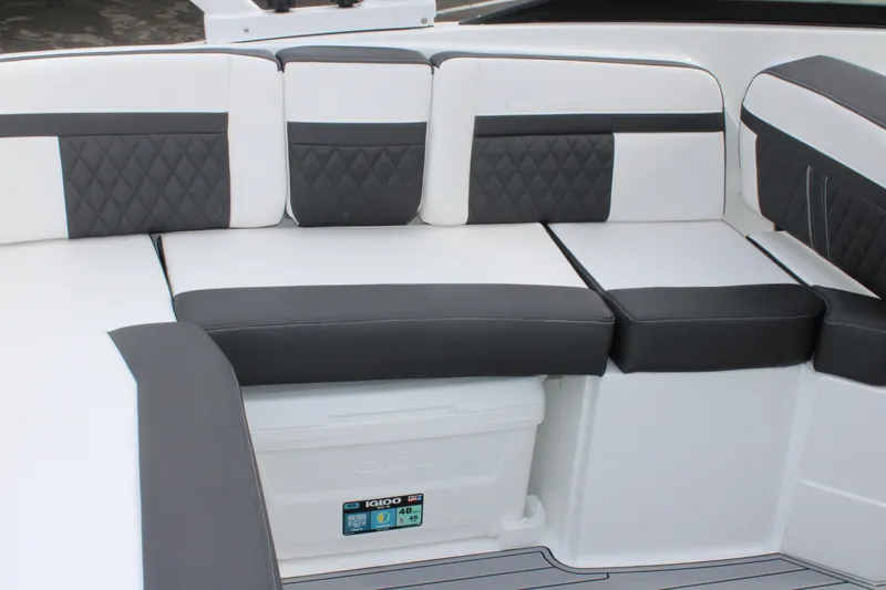 Slide: The Image of 2023 Monterey M6 boat interior with cushioned seating and built-in cooler. - 21