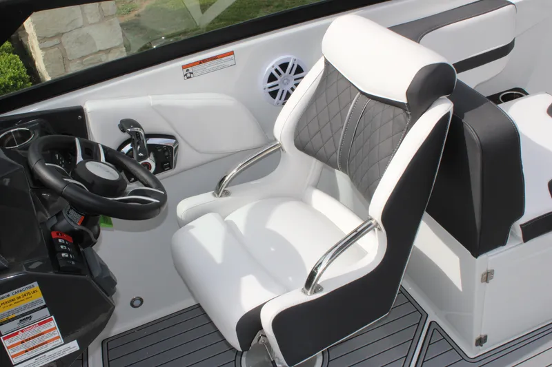 Slide: The Image of 2023 Monterey M6 boat cockpit with white and black captain's chair and steering wheel. - 32