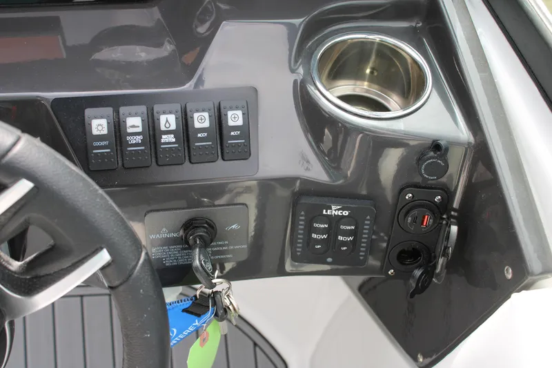 Slide: The Image of Control panel of 2023 Monterey M6 boat with switches, cup holder, and ignition keys. - 38