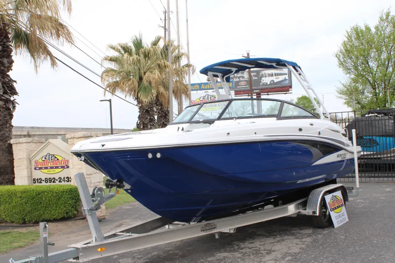 Slide: The Image of 2023 Monterey M6 boat on trailer, blue and white, displayed outdoors. - 4