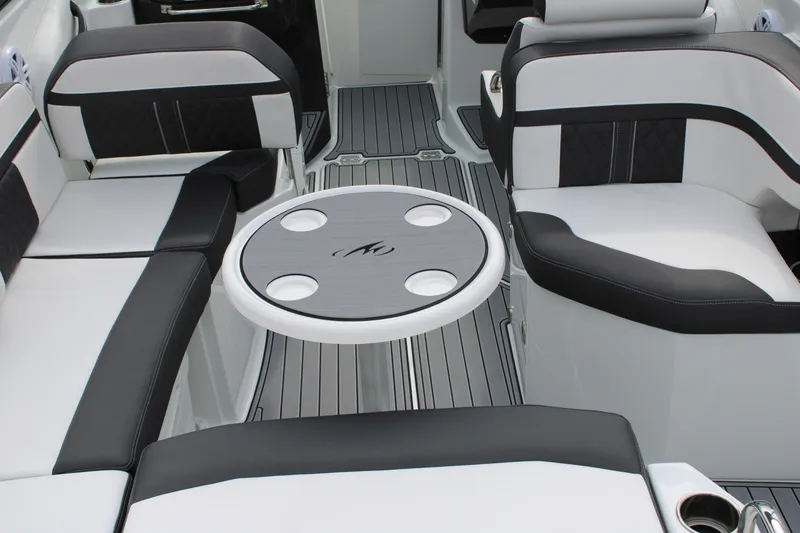 Slide: The Image of 2023 Monterey M6 boat interior with black and white seating and round table. - 45