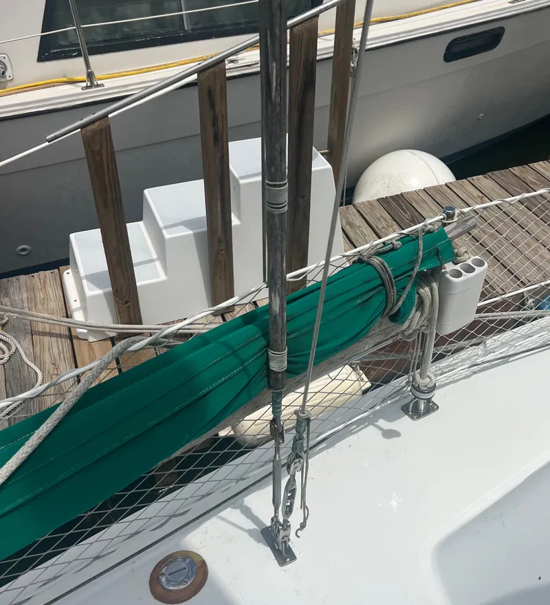 Slide: The Image of 1974 CAL T2 sailboat docked with green sail cover and wooden steps. - 15