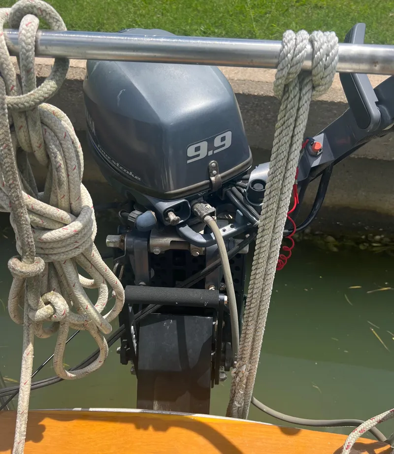 Slide: The Image of Outboard motor on a 1974 CAL T2 sailboat docked by the water. - 21