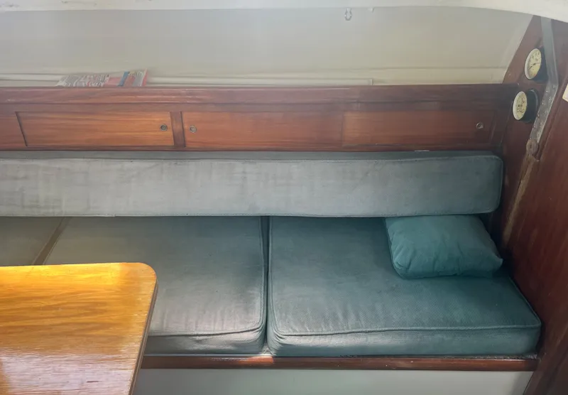 Slide: The Image of Interior of a 1974 CAL T2 sailboat with blue cushions and wooden cabinetry. - 24