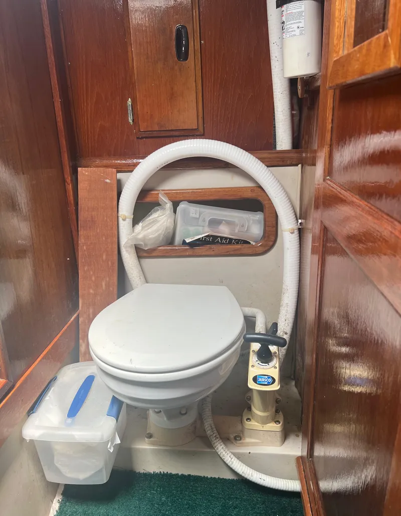 Slide: The Image of 1974 CAL T2 boat bathroom with marine toilet and wooden cabinetry. - 28