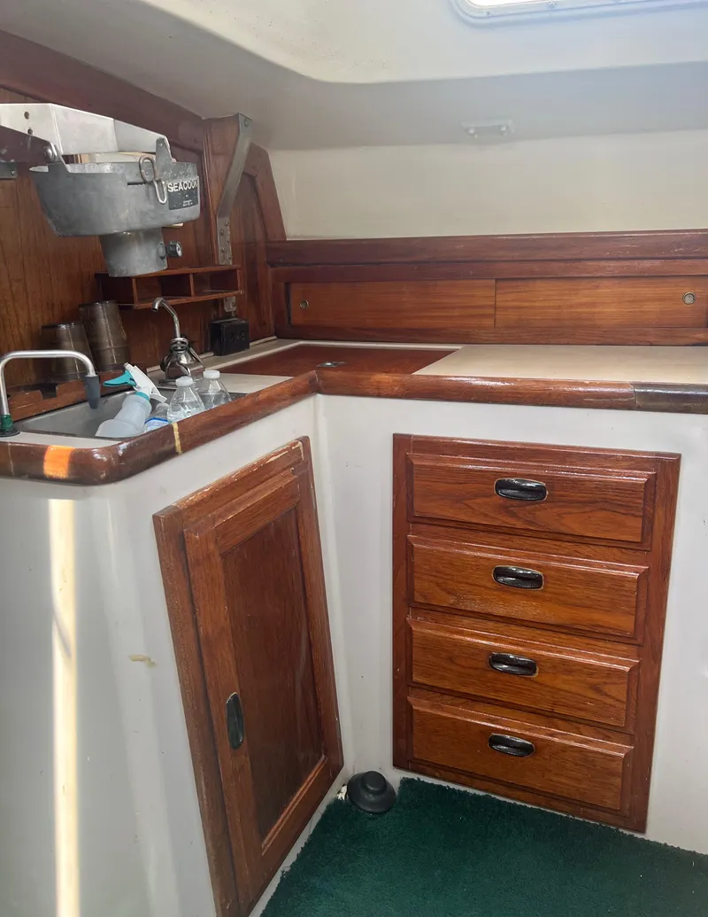 Slide: The Image of 1974 CAL T2 sailboat interior with wooden cabinets and drawers. - 30