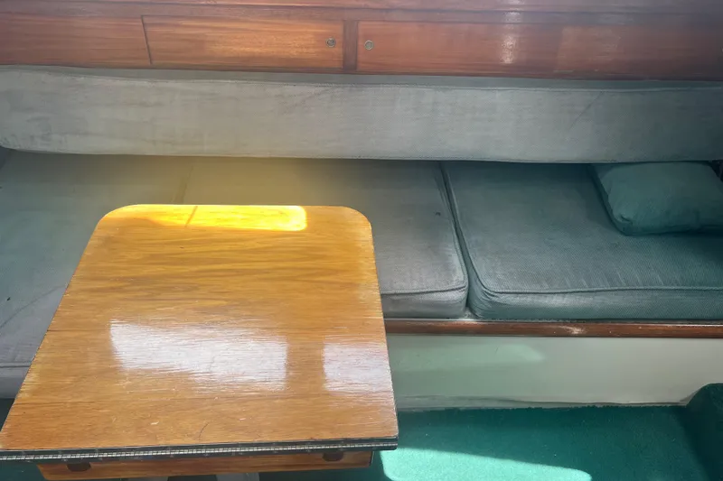 Slide: The Image of 1974 CAL T2 boat interior with wooden table and cushioned seating. - 34