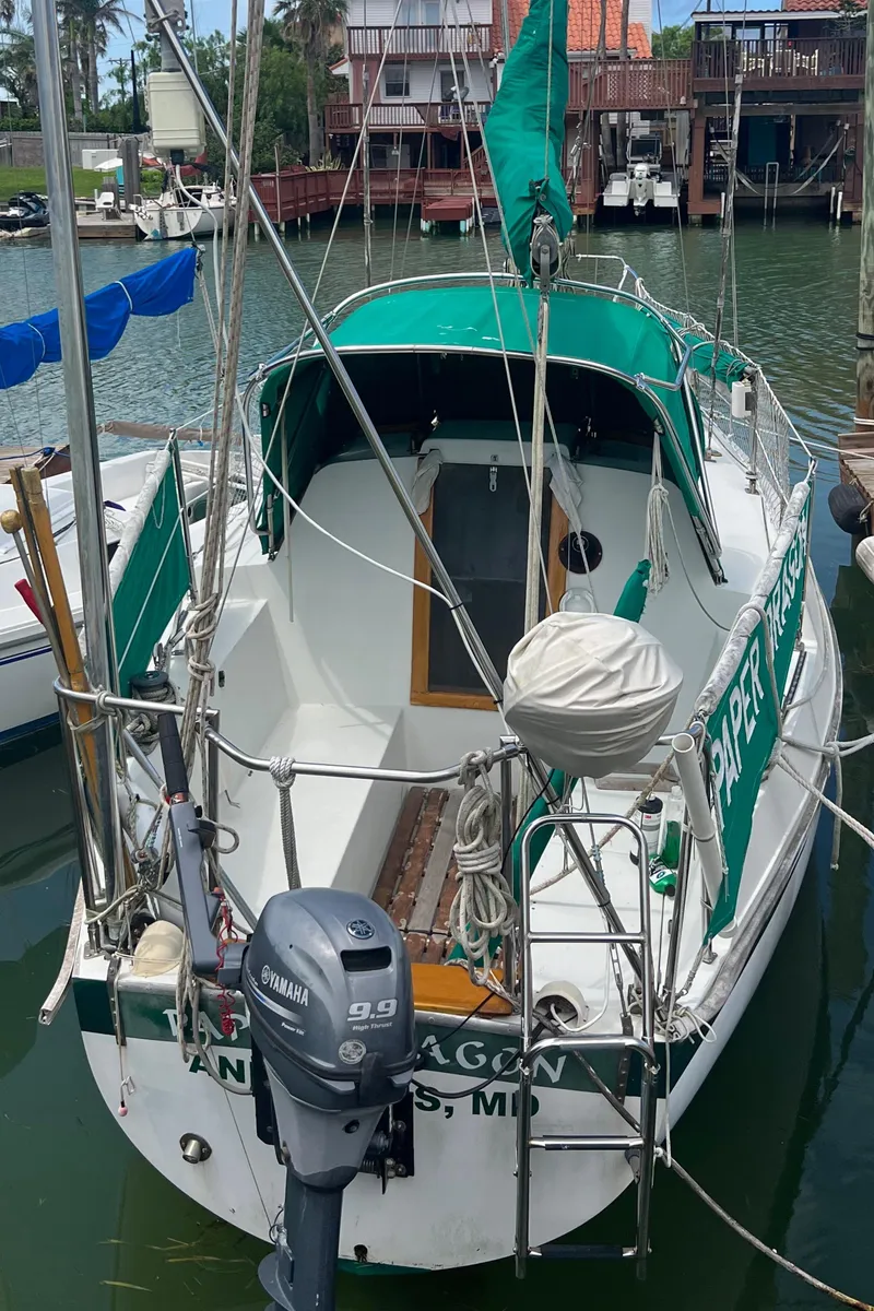 Slide: The Image of 1974 CAL T2 sailboat docked, featuring green canopy and Yamaha 9.9 outboard motor. - 4