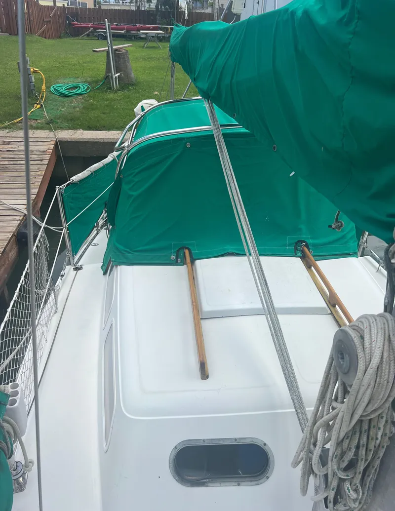 Slide: The Image of 1974 CAL T2 sailboat docked with green covers and ropes. - 8