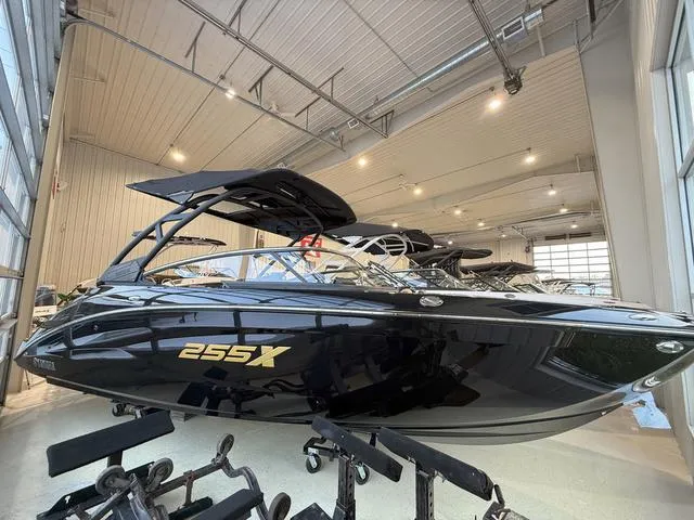 Slide: The Image of 2025 Yamaha Boats 255XD in showroom, sleek black design, modern features, luxury watercraft. - 1
