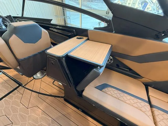 Slide: The Image of 2025 Yamaha Boats 255XD interior with tan seating and wooden table. - 11