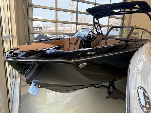 Slide: The Image of 2025 Yamaha Boats 255XD in showroom, sleek black design, modern interior. - 2