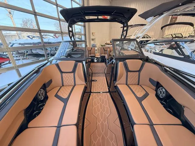 Slide: The Image of 2025 Yamaha Boats 255XD interior with luxurious seating and modern design in a showroom. - 24