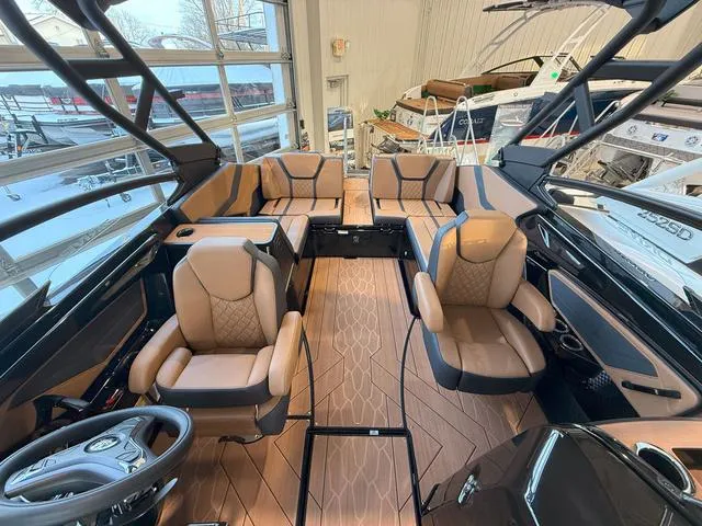 Slide: The Image of 2025 Yamaha Boats 255XD interior with luxurious seating and modern design in a showroom setting. - 25