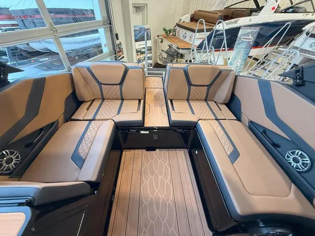 Slide: The Image of 2025 Yamaha Boats 255XD interior with luxurious seating and modern design in a showroom. - 6