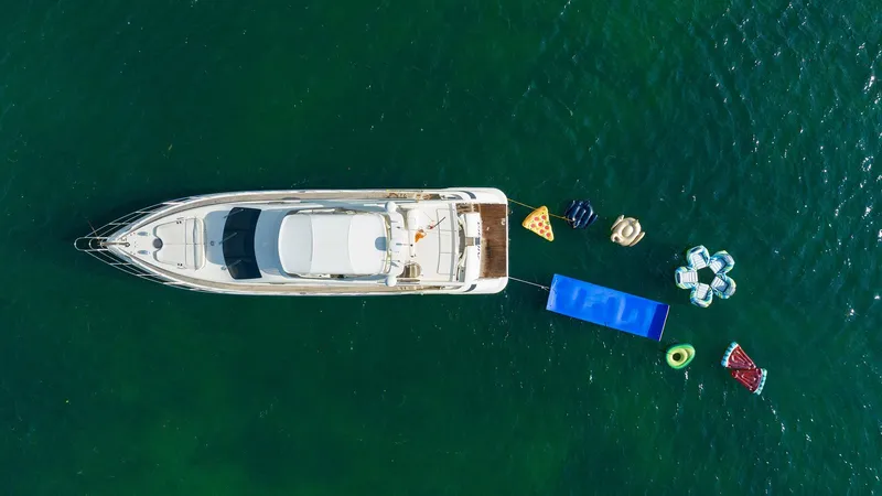 Slide: The Image of Aerial view of 2005 Azimut 62 Evolution yacht with colorful inflatables in the water. - 0