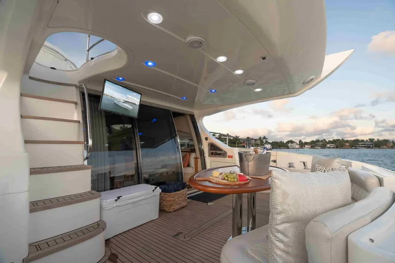 Slide: The Image of Luxurious 2005 Azimut 62 Evolution yacht deck with seating, table, and scenic water view. - 13