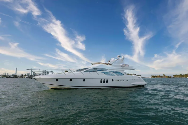 Slide: The Image of 2005 Azimut 62 Evolution yacht on open water under a clear blue sky. - 2