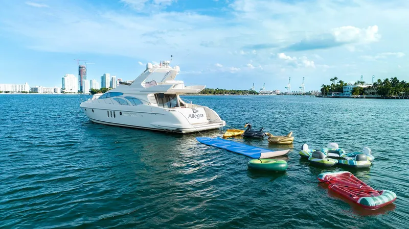Slide: The Image of Azimut 62 Evolution yacht on water with inflatables, city skyline in background. - 32