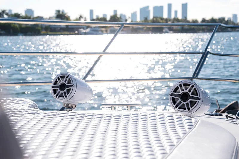 Slide: The Image of Azimut 62 Evolution yacht deck with speakers, ocean view, and city skyline in background. - 6