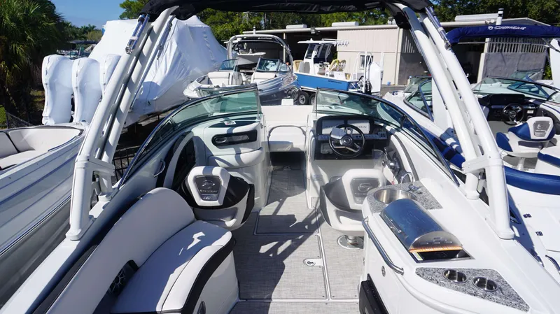 Slide: The Image of 2024 Crownline E 290 XS boat interior with helm, seating, and amenities. - 10