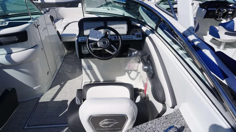 Slide: The Image of 2024 Crownline E 290 XS boat cockpit with steering wheel and Garmin navigation system. - 15