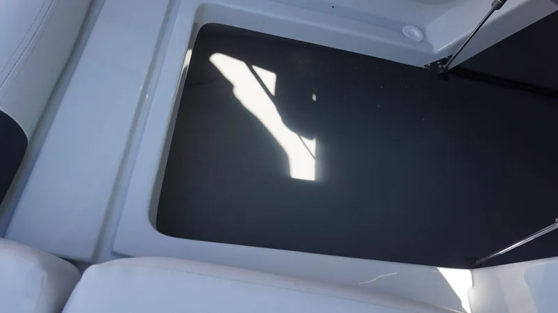 Slide: The Image of 2024 Crownline E 290 XS boat storage compartment with white and black interior. - 3