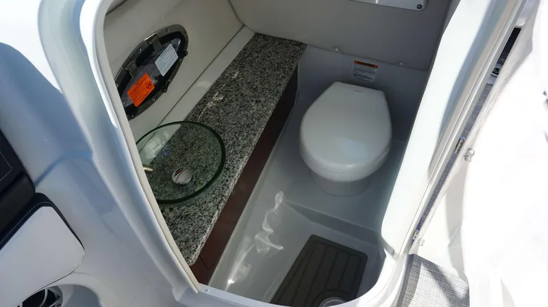 Slide: The Image of 2024 Crownline E 290 XS boat bathroom with granite countertop and modern fixtures. - 5
