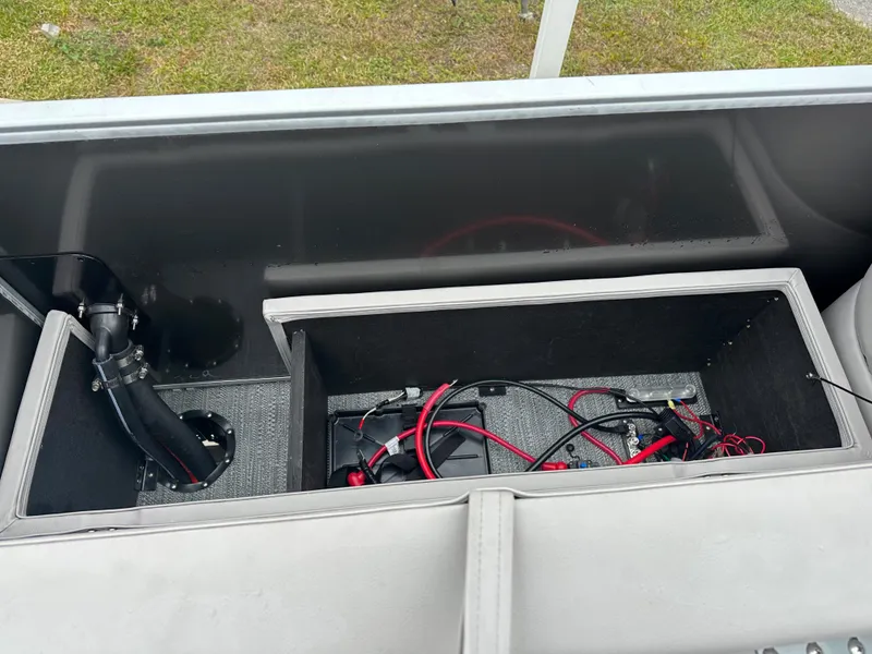 Slide: The Image of 2024 Sweetwater EX2286FX boat storage compartment with wiring and battery setup. - 10