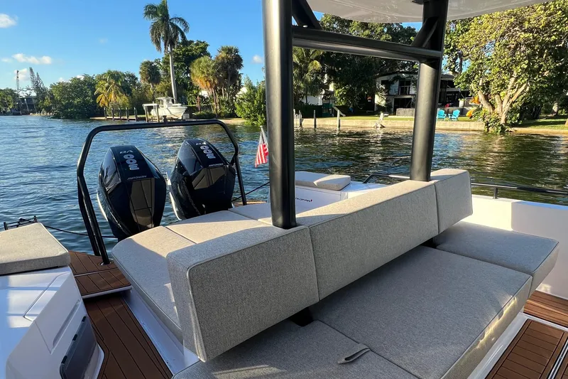 Slide: The Image of 2023 Axopar 37 Sun-Top boat with twin engines docked by a scenic waterfront. - 16